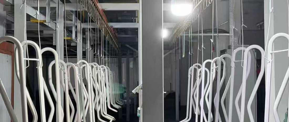 Rows of NOOKI carbon-steel bed frames on the powder-coat line