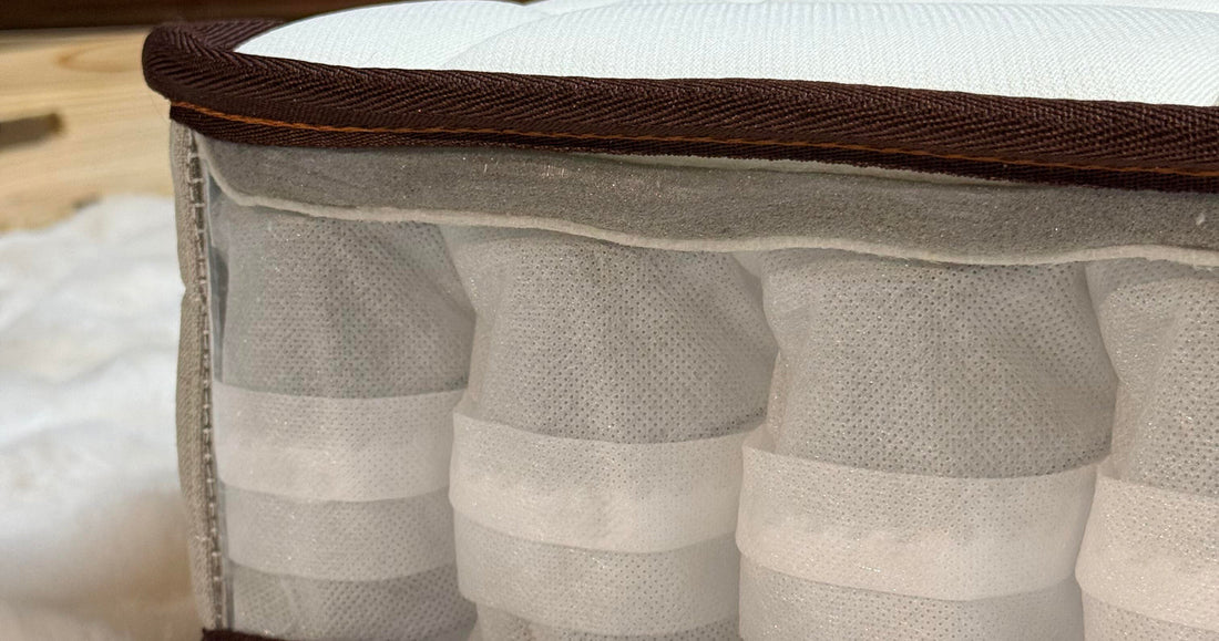 Close-up of the NOOKI OrthoFlex mattress transparent side, showing a row of individually wrapped pocket springs